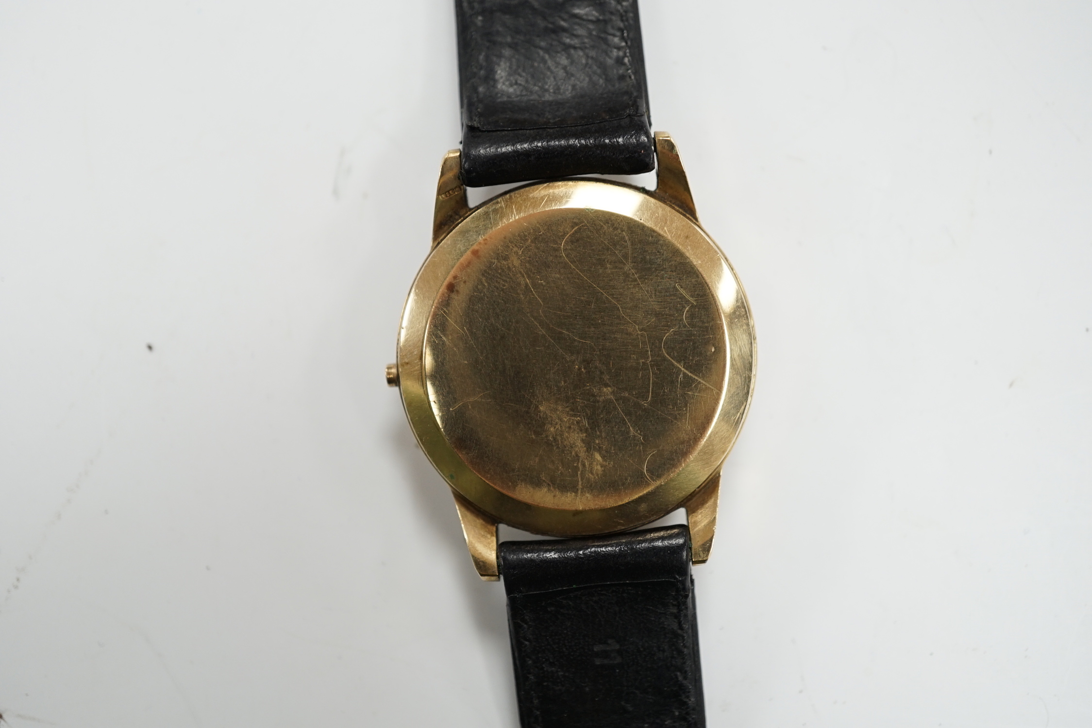 A gentleman's 9ct gold Omega manual wind black dial wrist watch (lacking winding crown), on associated leather strap, case diameter 35mm.